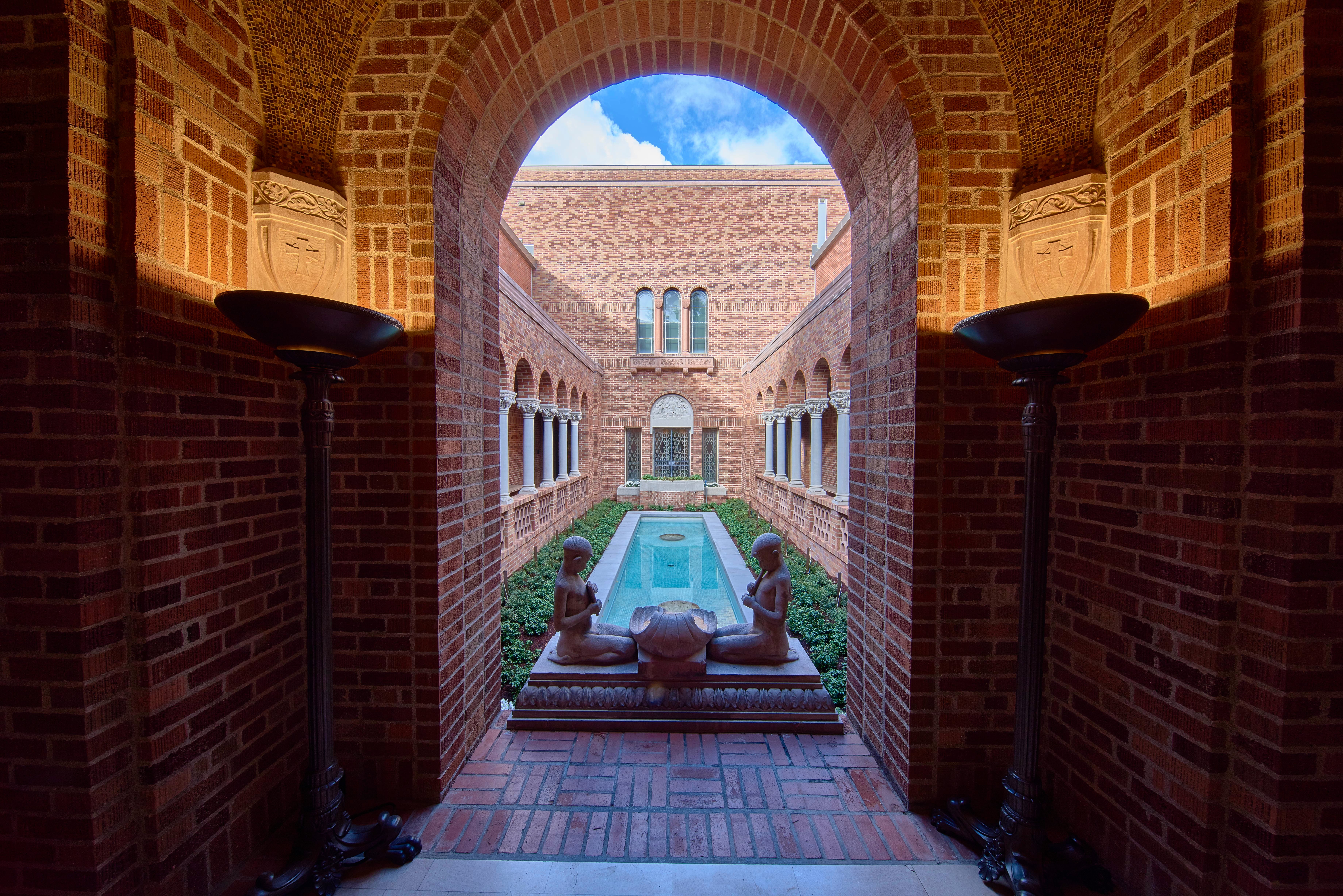 The Jordan Schnitzer Museum of Art's brick courtyard frames a reflecting pool and sculptures.