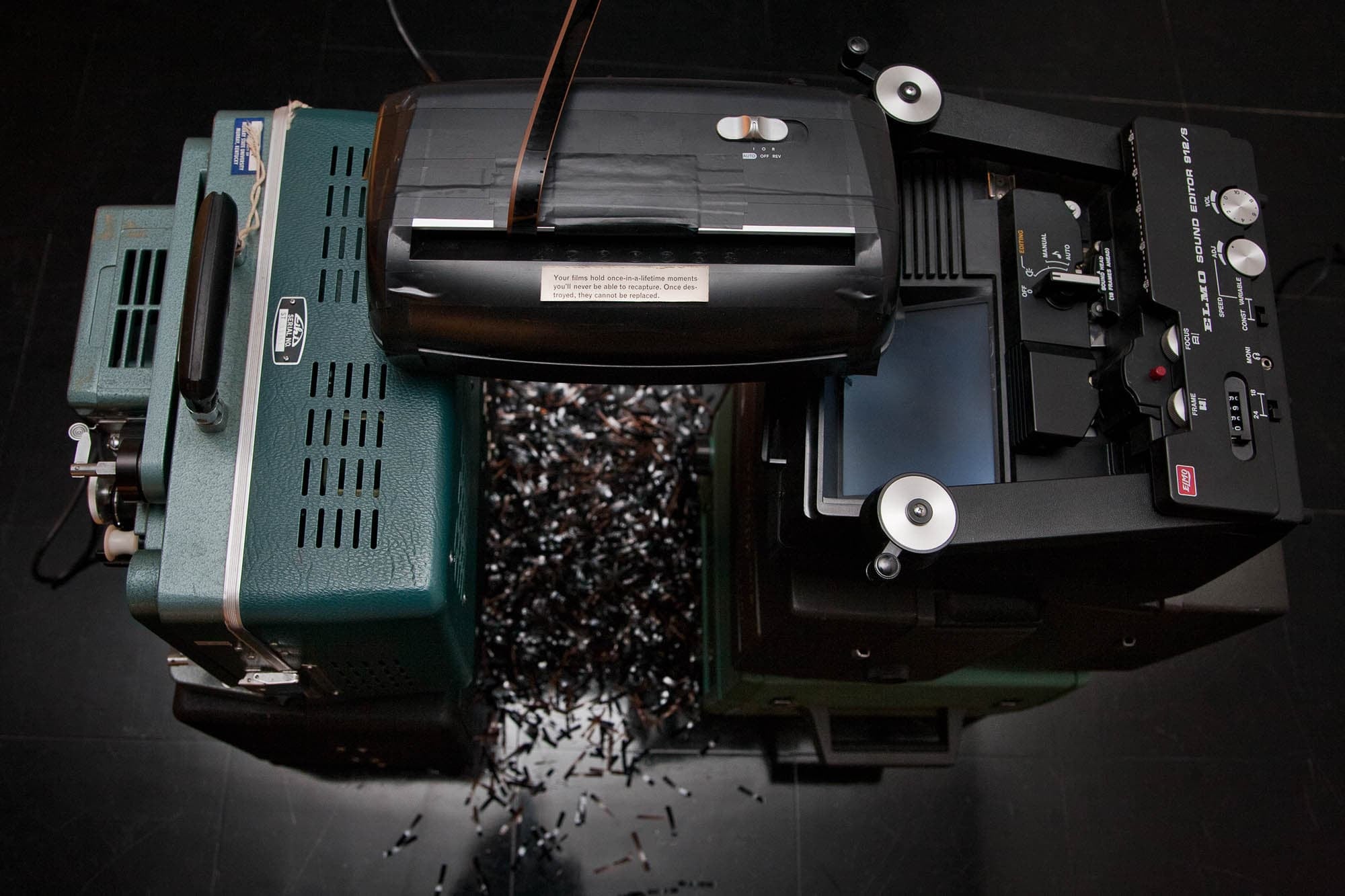 Shredder over a pile of shredded film with the message “Your films hold once-in-a-lifetime moments you’ll never be able to recapture. Once destroyed, they cannot be replaced” on it