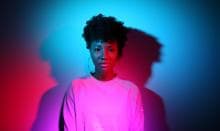 A portrait of a woman lit with red and blue lights creating dark shadows and vibrant colors.
