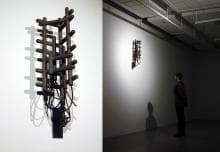 A dual photo of a closeup of an artwork that looks like something vaguely mechanical and yet biological, and a photo of a man looking at the same artwork that is hung on the wall.