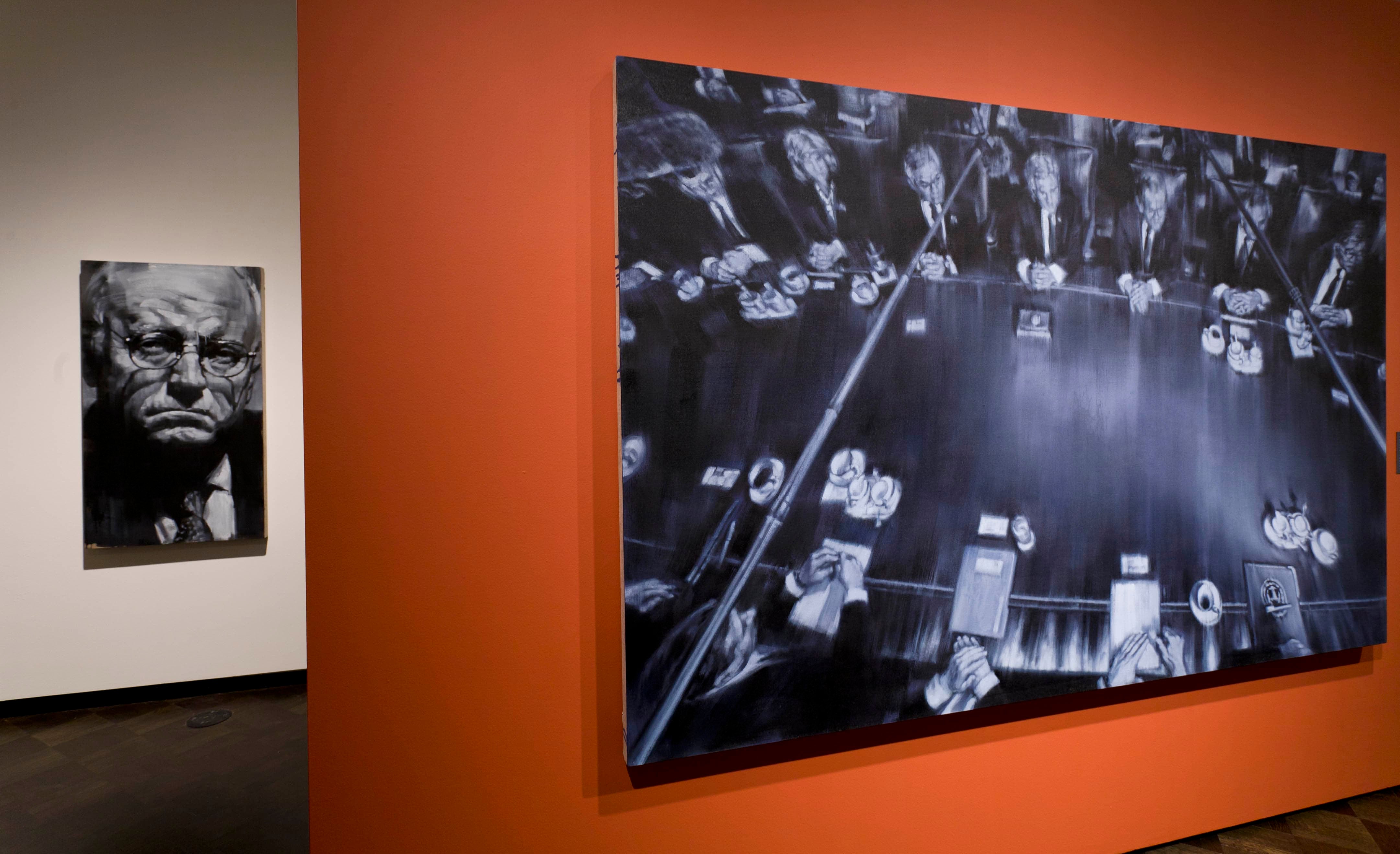 Gallery view of two artworks, one an overhead shot of people sitting at a conference table and the other a closeup portrait of Dick Cheney
