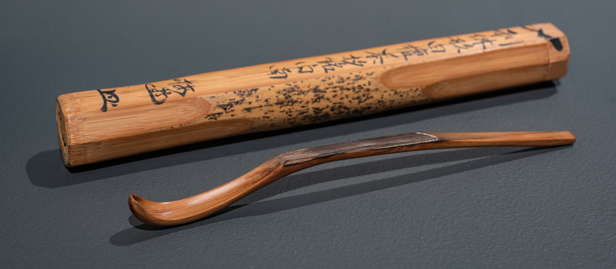 Wooden tea spoon and case with Japanese writing etched into it.