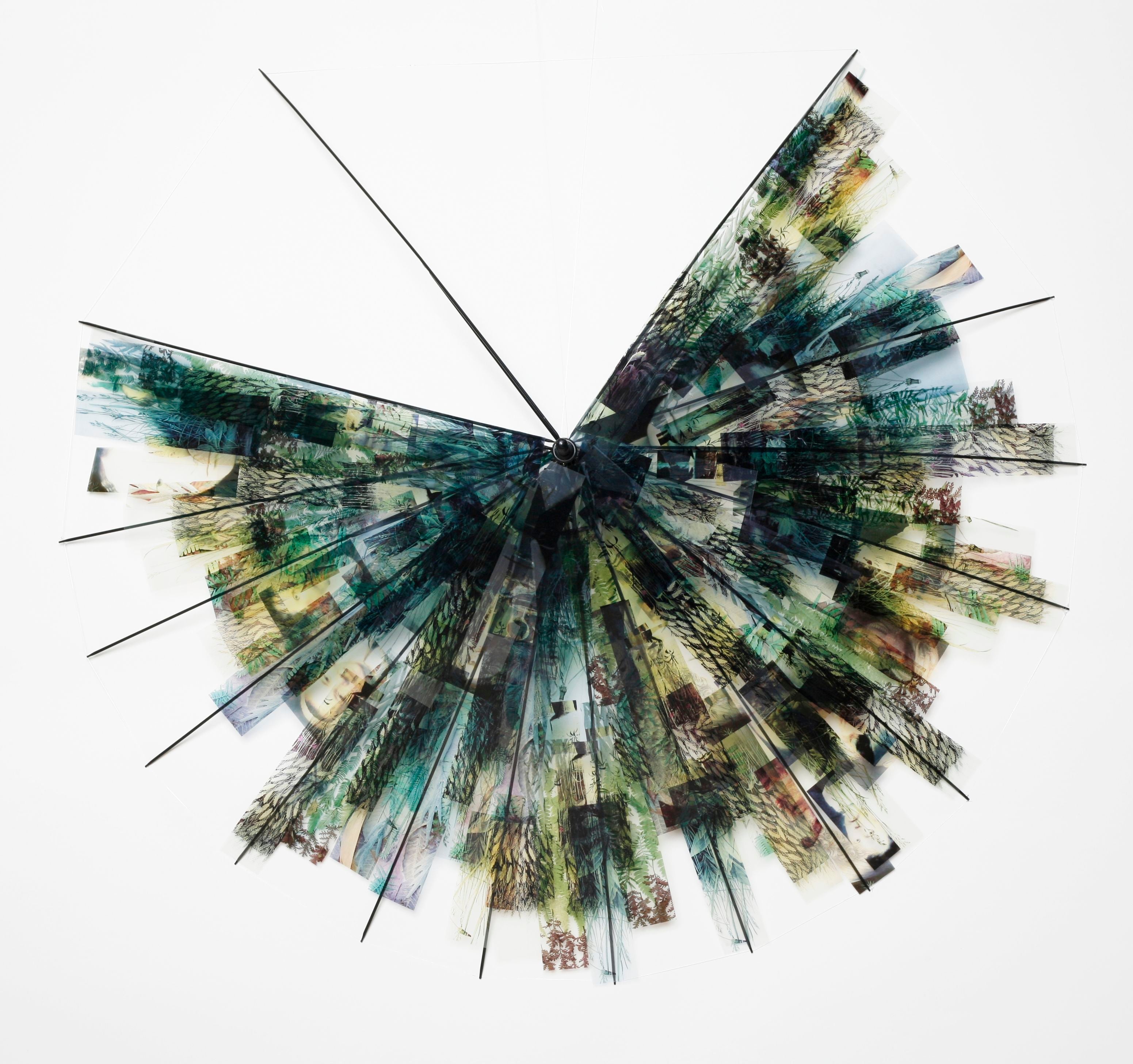 An umbrella frame with the fabric replaced with film negatives on a white background