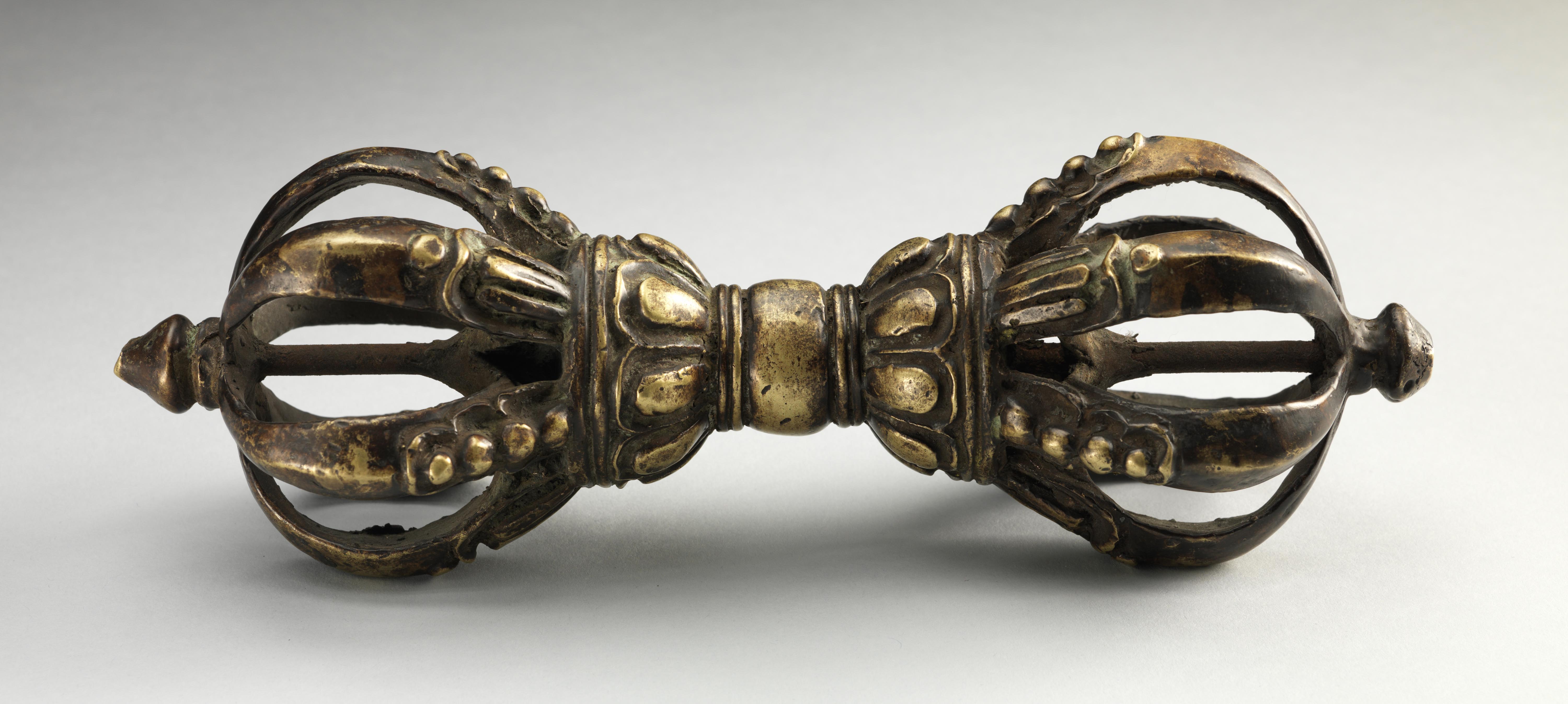 Gold Tibetan artifact with two egg shaped crowns on each end.