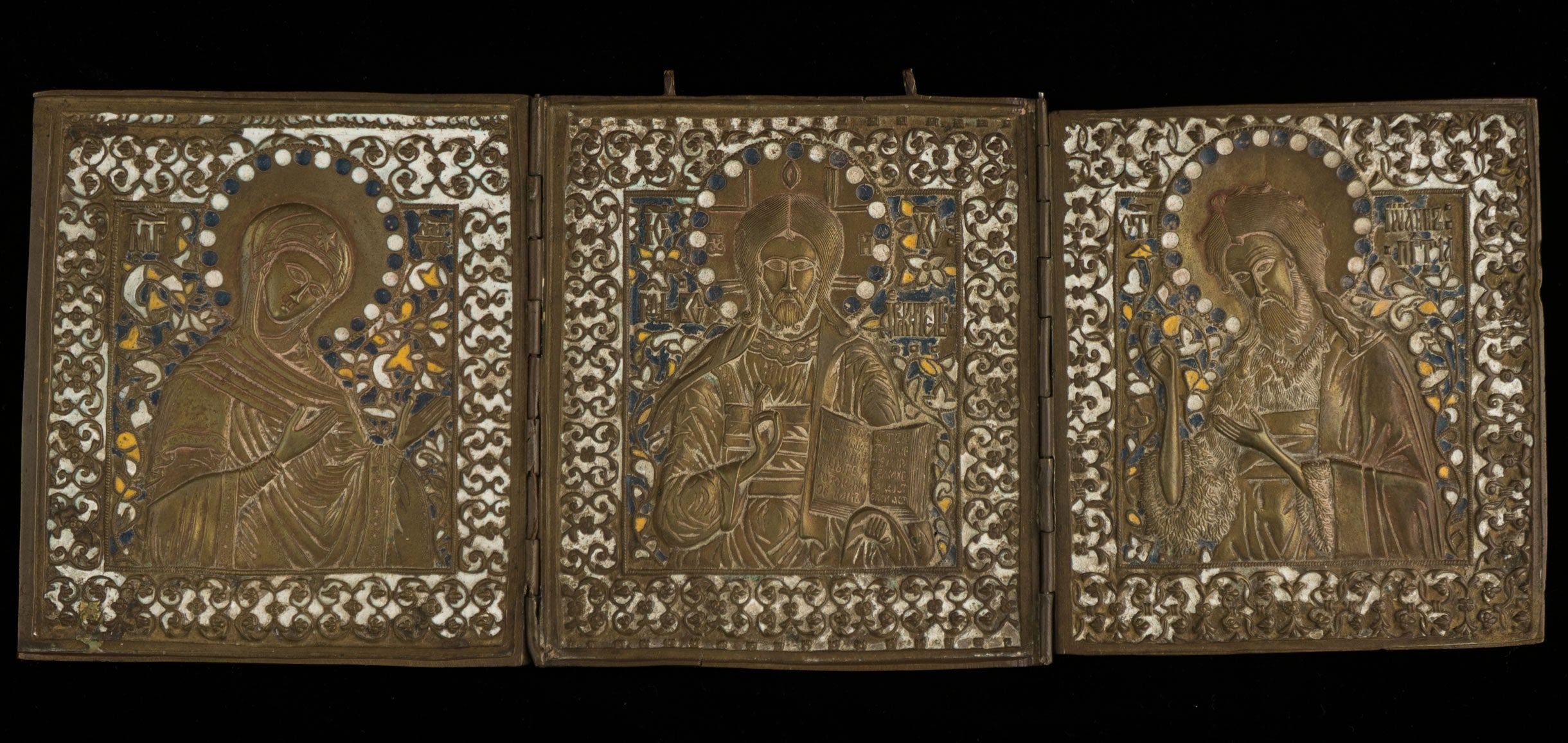 A triptych made of metal showing three Russian saints