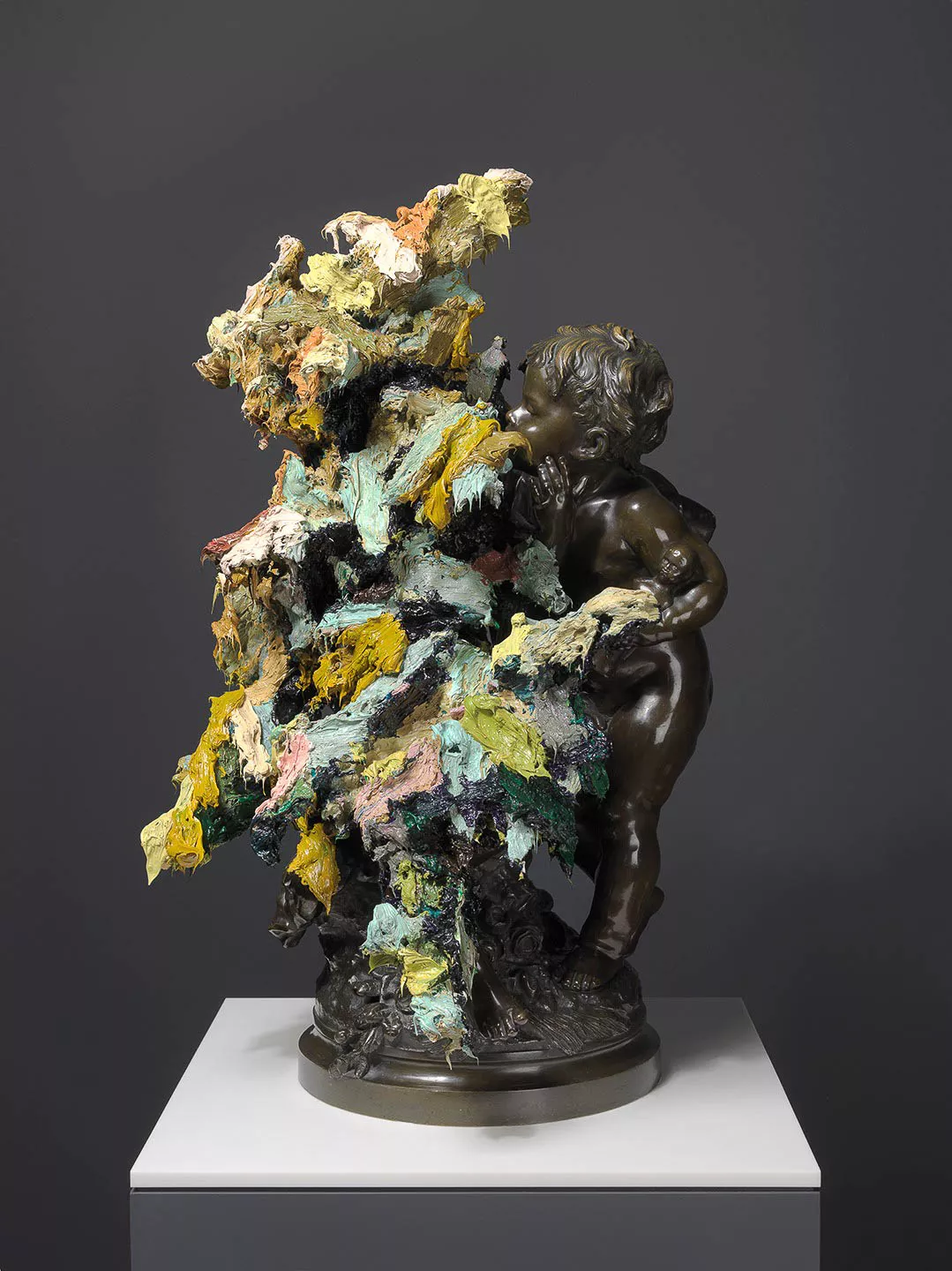 Bronze sculpture of a child peeking around a colorful, textured tree.