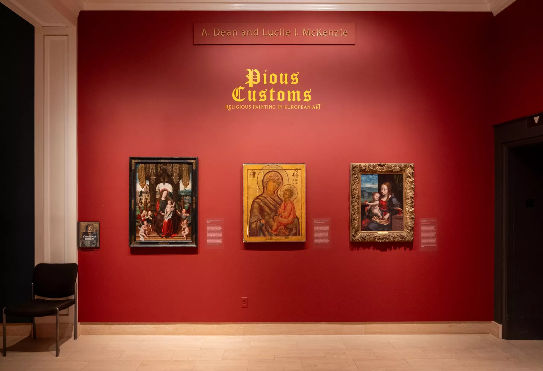 Gallery with red walls and religious icons on the wall.