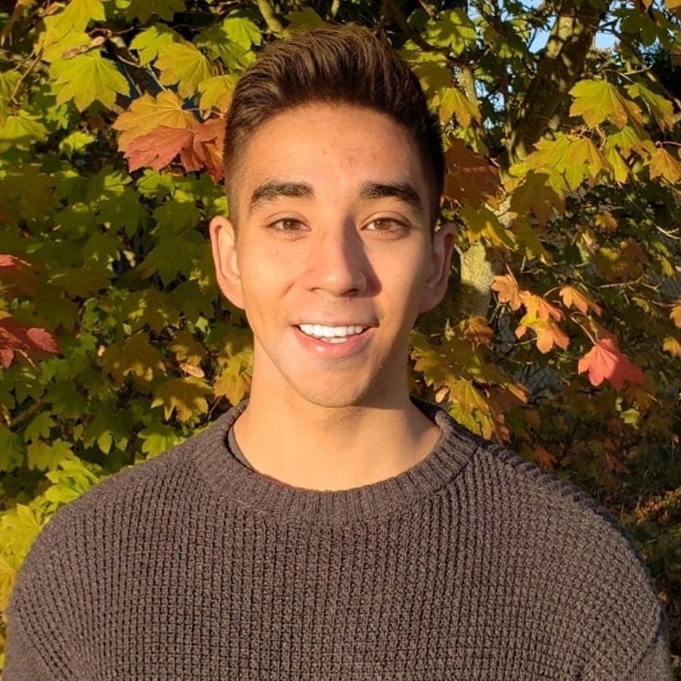 Knight Campus Undergraduate Scholar Alonso Cruz with leafy backdrop