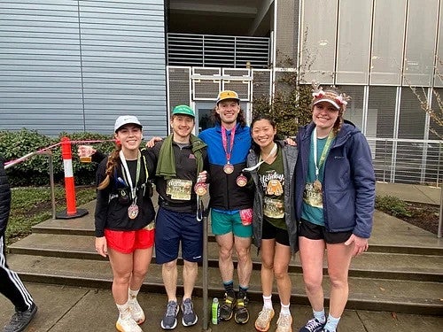 A group of people after running a race, with their medals, smiling 