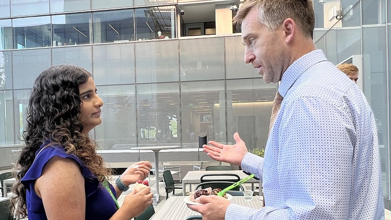 Woman on left talking to man on outdoor terrace