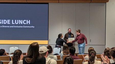 People shaking hands receiving an award