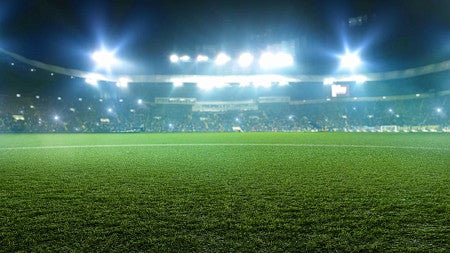 Soccer field grass, with stadium lights in the background