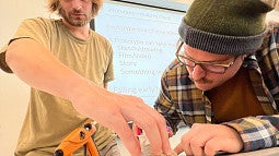 Two people work on a craft project