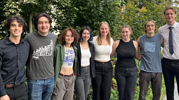 A group of college students standing on an outdoor terrace