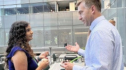 Woman on left talking to man on outdoor terrace