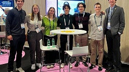 Group of students stand in convention center 