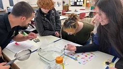 Young scientist with high school students at science outreach event
