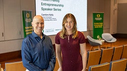 Man and woman in front of slide promoting science talk