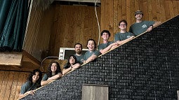 Students at the BRIN showcase event during Eugene Beer Week, standing on a staircase and smiling