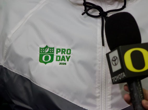 A former Oregon football player wears a special Pro Day jacket as he's interviewed.