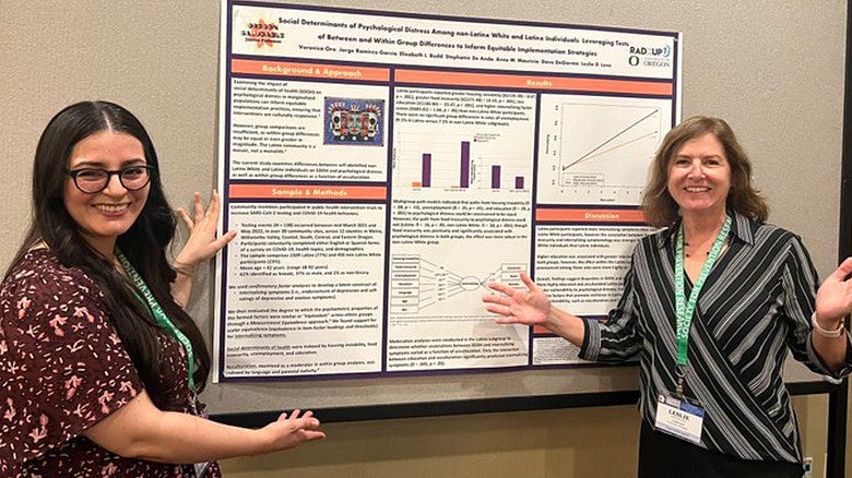Leslie Leve with a student poster presentation