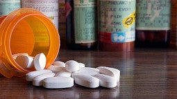 image of a medicine bottle with pills spilling out onto a table
