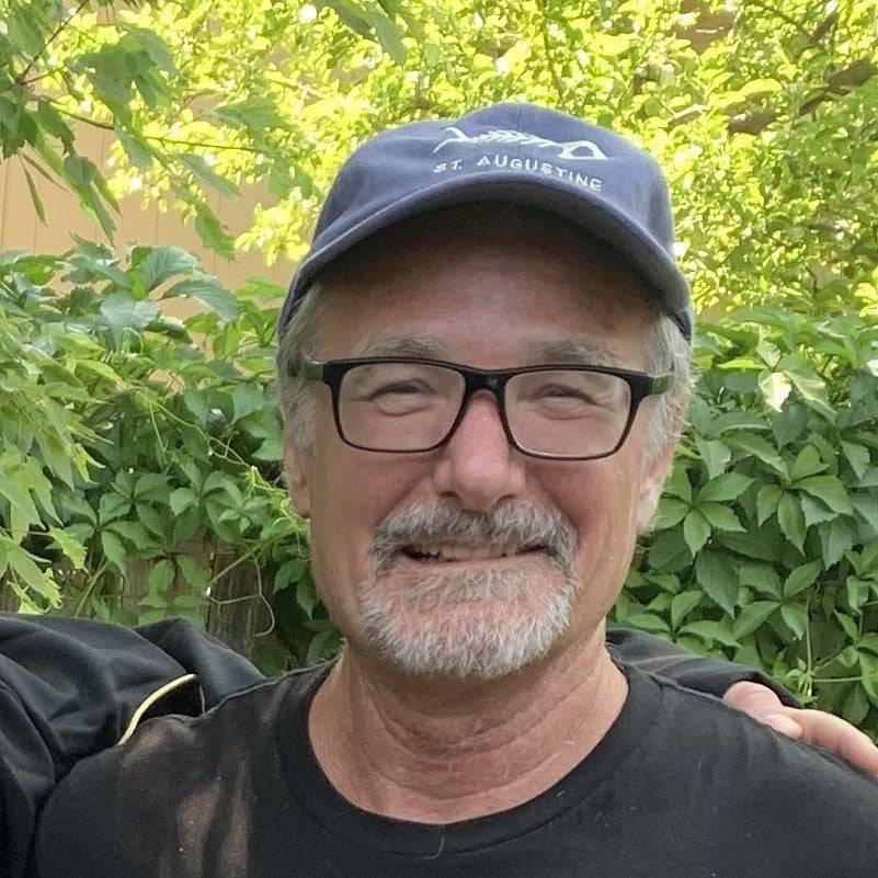 Bob Parker. Shows a man with glasses and hat in front of a bunch of different green plants. 