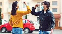 Photo of two people elbow bumping