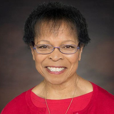 Denyse McGriff Photo. Shows a woman with glasses smiling into the camera. 