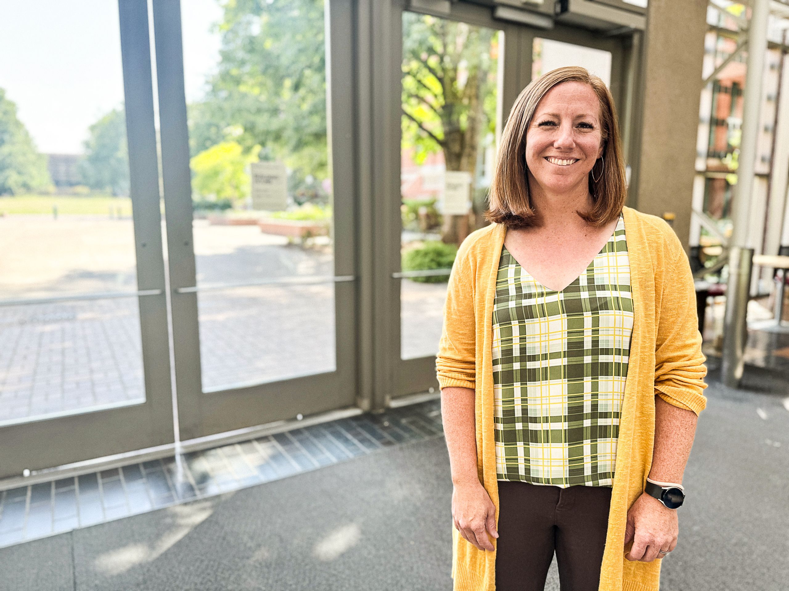 Photo of Trish Dorman standing, facing the camera, and smiling.