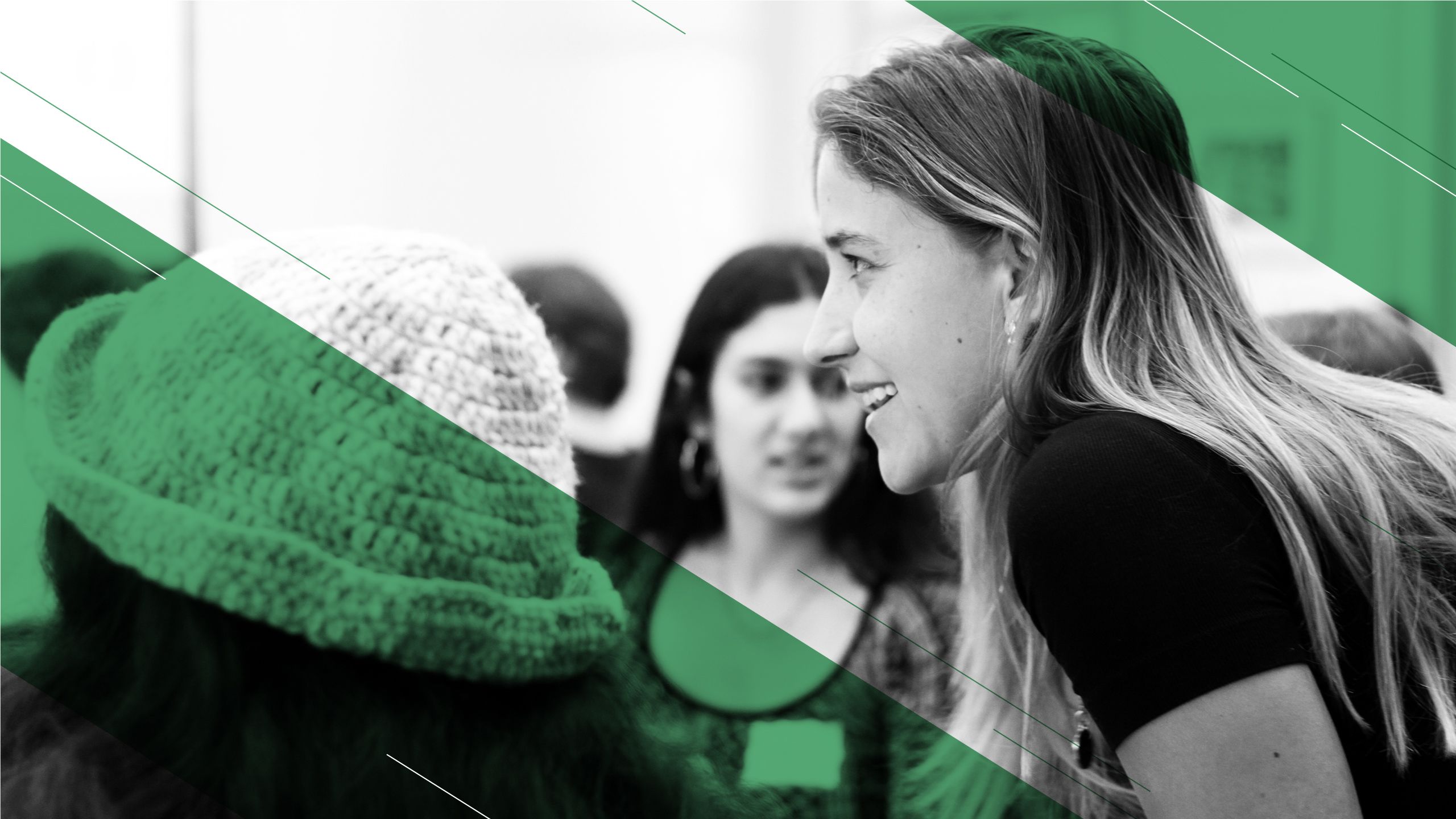 A close-up of one student leaning towards and talking to another student, with an added green overlay.