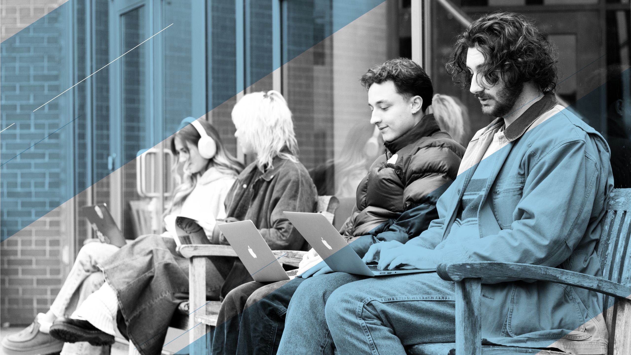 Four students sitting outside on benches, working on laptops, with an added blue overlay.