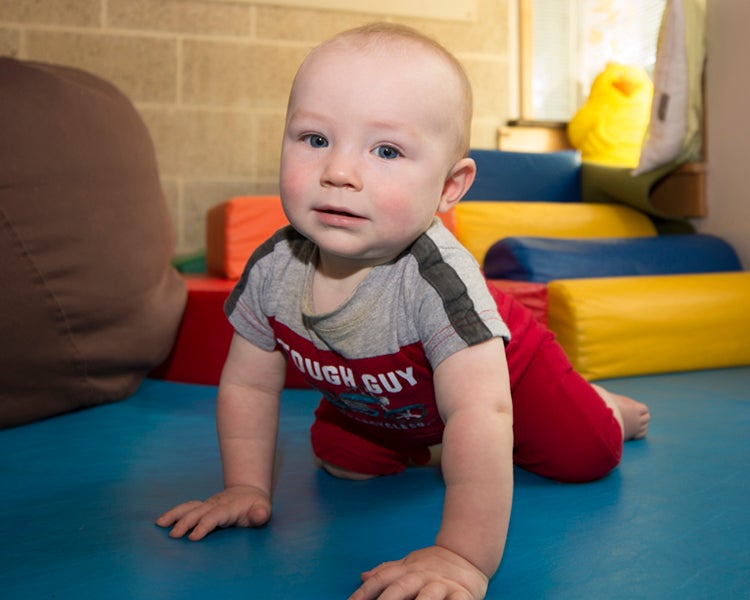 Infant crawling on soft mats.