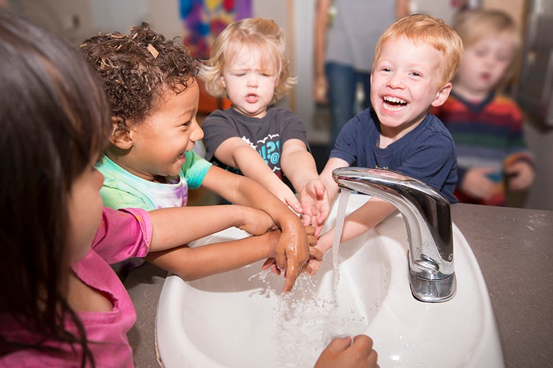 4 children washing hands after classroom activities.