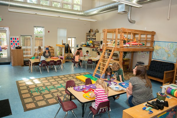 Classroom offers several project tables and features a ladder treehouse reading area.