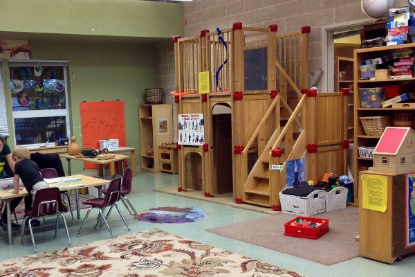 Classroom features a step latter play unit, soft mats, games, and activity tables.