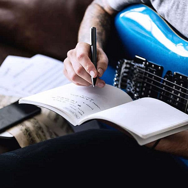 guitarist writing in a notebook