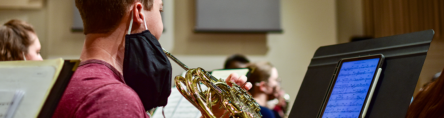 student performing brass instrument