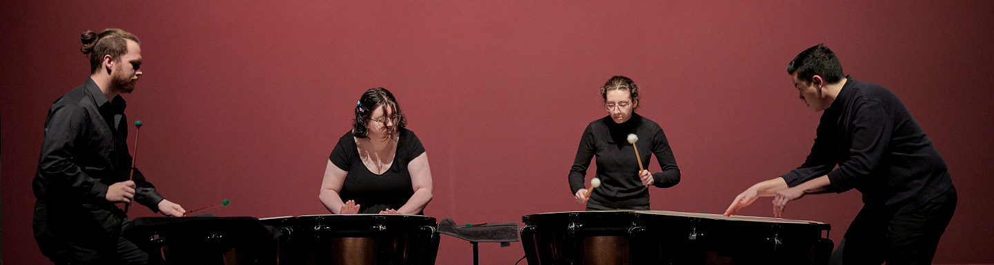 Four percussion students playing their instrument