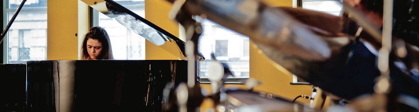 distant view of student playing piano