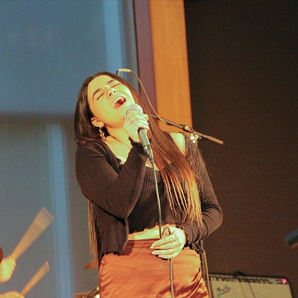 student singing holding microphone