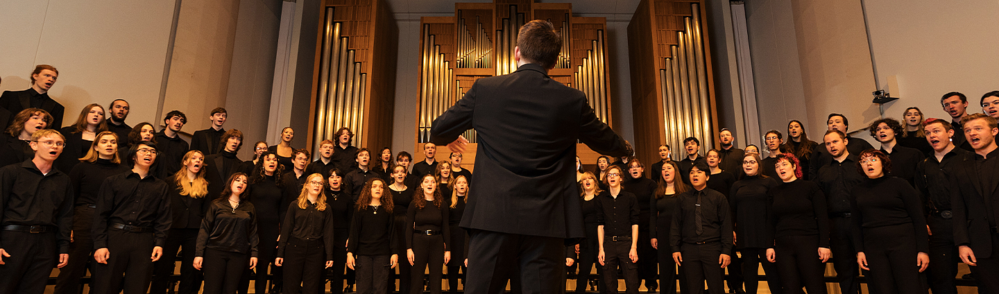 Graduate student conducting a choir in Beall