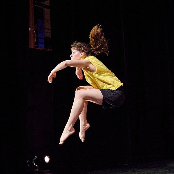 student mid jump in dance routine