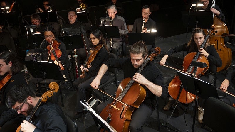 Adam Broce (pictured center) performs with Orchestra Next