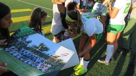 Alyssa Signing a poster after oregon soccer game