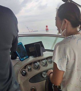Grace driving a boat