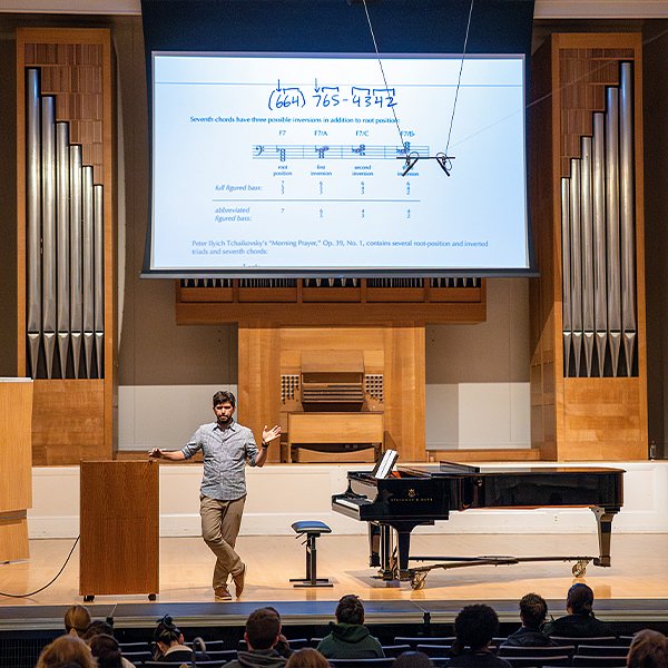 Faculty member lecturing in Beall Concert Hall