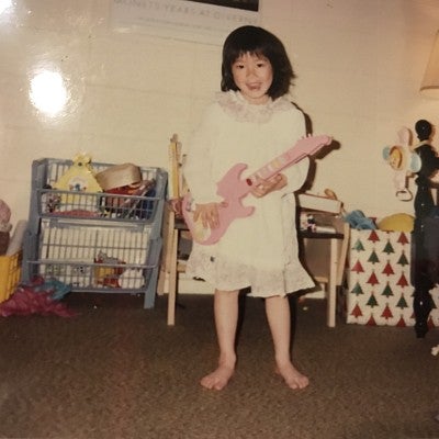 Grace playing with her toy guitar as a child
