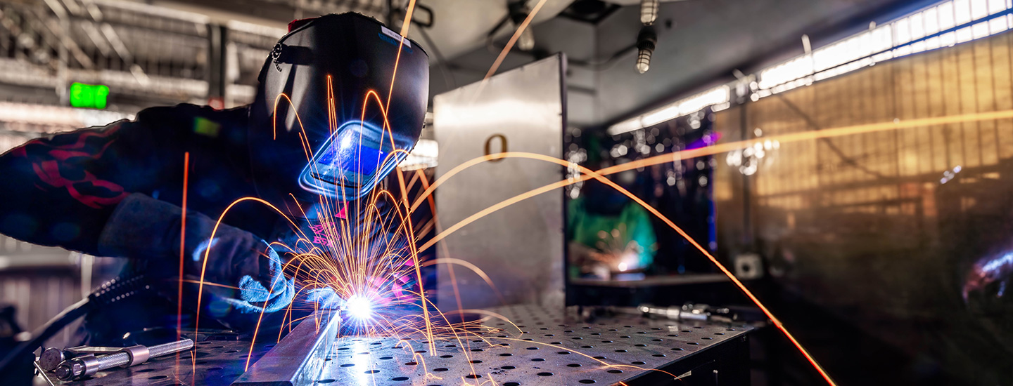 Craft Center member using plasma torch on metal parts