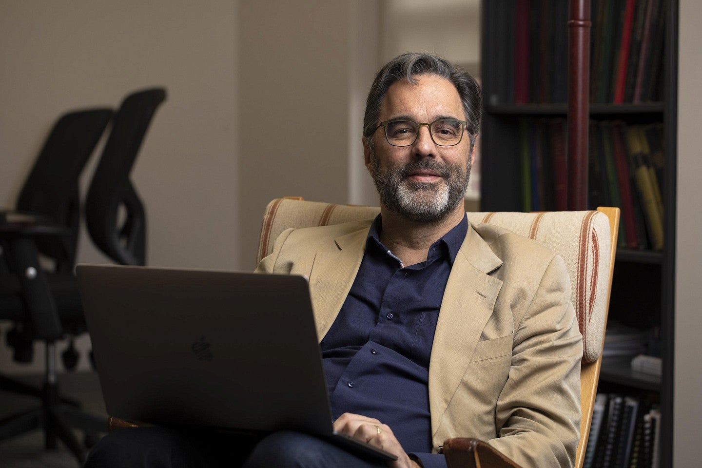 a person sitting in a chair with a laptop